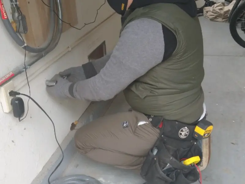 Electrician performing outlet wiring in a Egelston garage